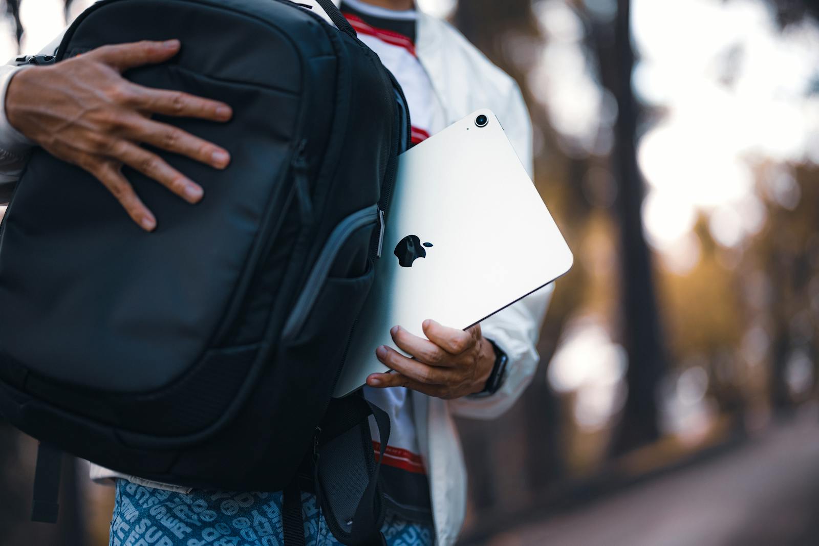 Person with a tablet and a travel backpack